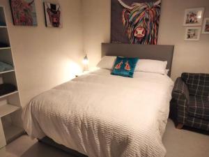ein Schlafzimmer mit einem Bett mit einem Kuhbild an der Wand in der Unterkunft The Studio Castlerock with Hot Tub in Coleraine
