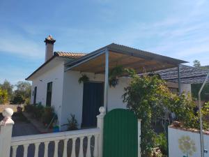 een wit huis met een houten dak aan een hek bij Alojamiento Rural La Perdiz in La Puebla de los Infantes
