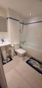 La salle de bains est pourvue de toilettes, d'une baignoire et d'un lavabo. dans l'établissement No 11 3 BED SERVICED APPARTMENT TOWN CENTRE, à Girvan