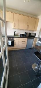a kitchen with white cabinets and a tile floor at No 11 3 BED SERVICED APPARTMENT TOWN CENTRE in Girvan