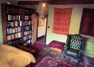 um quarto com uma cama e uma estante de livros com livros em Nutclough Cottage - Log Fire and Valley View - Sleeps 2 em Hebden Bridge