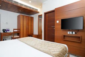 a bedroom with a bed and a flat screen tv at Nexstay River Mouth International in Ferokh