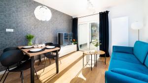 a living room with a blue couch and a table and chairs at Domki Sun & Snow Sikorskiego II in Karpacz