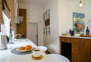 a kitchen with a plate of croissants and a cup of coffee at BB Residence Sololaki in Tbilisi City +53 photos