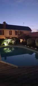 uma grande piscina em frente a uma casa em L'Arbre d'Alaïs em Saint-Fulgent