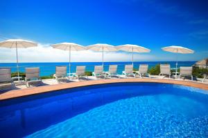 
a beach with a pool, chairs, and umbrellas at Hotel Servigroup Montíboli in Villajoyosa

