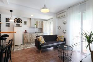 a living room with a couch and a kitchen at NEW Apartamento Tierra Andaluza junto Mezquita in Córdoba