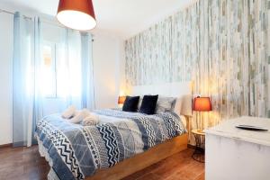 a bedroom with a bed with a blue and white blanket at NEW Apartamento Tierra Andaluza junto Mezquita in Córdoba