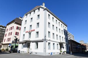 un edificio blanco en la esquina de una calle en Hotel de France en La Chaux-de-Fonds