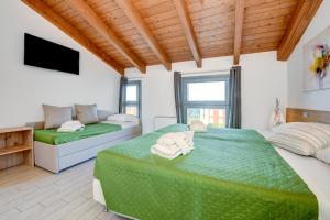 sypialnia z zielonym łóżkiem i kanapą w obiekcie Borgo Gasparina Family Apartments w mieście Castelnuovo del Garda +37 zdjęć
