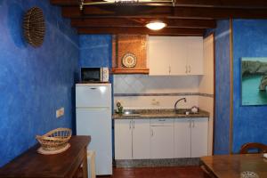 a kitchen with a white refrigerator and a table at Ereba, casa en Nueva a 3 km de la playa CA-33-AS in Llanes +18 photos