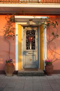 uma porta num edifício com dois vasos em Beautiful Traditional House in Lefkada em Lefkada