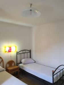 ein Schlafzimmer mit 2 Betten, einer Lampe und einem Stuhl in der Unterkunft Casa Vacanza Giovanna nr 52 contrada Mezzacampa località Caporasocolmo Messina in Messina
