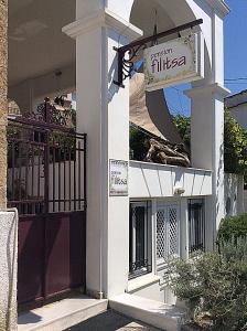 a white building with a sign on the side of it at Pension Filitsa in Pylos