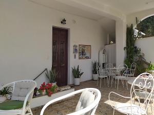 a living room with white chairs and a table at Pension Filitsa in Pylos