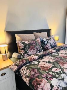 a bed with a floral comforter and two pillows at Zizi's House Gării 2 in Braşov