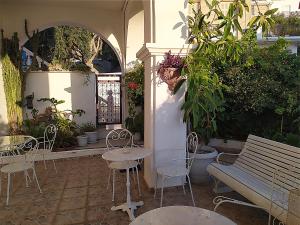 a patio with tables and chairs and a bench at Pension Filitsa in Pylos +53 photos