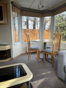 a living room with a table and chairs at Dedham Lodge in Lawford