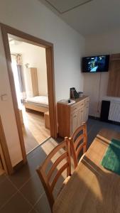 a living room with a table and chairs and a television at Penzion U Tomanů in Jaroměřice na Rokytné