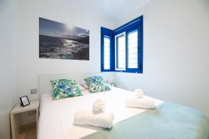 a white bedroom with a bed with two towels at MODERN APARTMENT NEXT TO THE BEACH, Pets friendly in Benalmádena