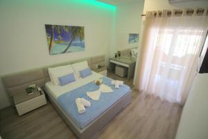 a bedroom with a bed with towels and a sink at Zero Zero Apartments Sarande in Sarandë