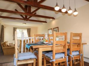 a dining room with a wooden table and chairs at Tilly Mint Cottage in Penrith
