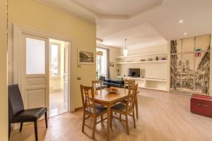 a dining room and living room with a table and chairs at Lovely 4-bedroom apartment 30m SanGiovanni metro in Rome