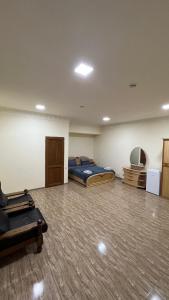 Habitación grande con cama y silla. en Hotel Hovit, en Bagratashen