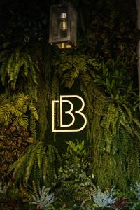 a sign with the letter b on a wall with plants at BB Residence Sololaki in Tbilisi City