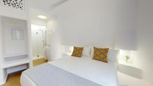 
a bedroom with a white bedspread and white pillows at Hotel Suite Generis - in Córdoba
