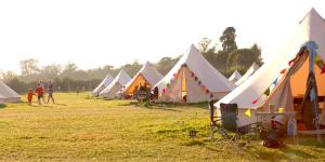 Une rangée de tentes dans un champ avec des gens se promener dans l'établissement Glamping at Hay Festival, à Hay-on-Wye