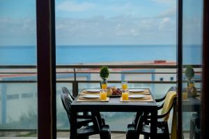 a table with food and drinks on a balcony at The Family Apart Beach in Ericeira