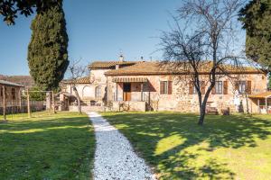 an old stone house with a pathway in front of it at agriturismo l'arte dei semplici in Montalcino