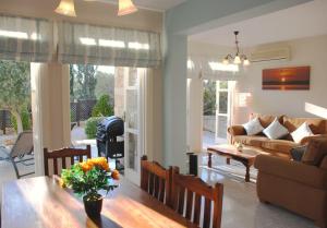 uma sala de estar com um sofá e uma mesa em Villa Nefeli - charming townhouse in the heart of Aphrodite Hills Resort em Kouklia