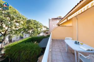 een klein balkon met een witte tafel en stoelen bij Apartamentos El Castell Casa Azahar in Alcossebre