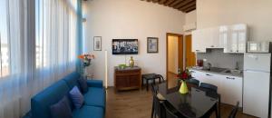 a living room with a blue couch and a kitchen at TINTORETTO VISTA REAL VENICE in Venice