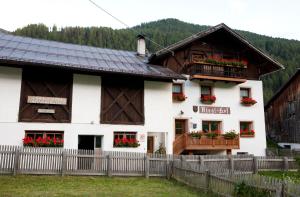 dom z kwiatami na balkonach w obiekcie Rieglhof Apartment Hennennest w mieście Caprone