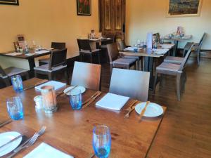 ein Esszimmer mit Tischen, Stühlen, Tellern und Gläsern in der Unterkunft Hartfell Guest House in Moffat