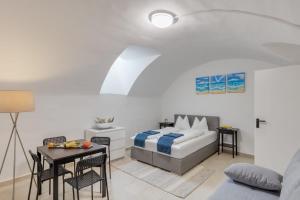 1 dormitorio con 1 cama, mesa y sillas en Cozy Flat near City Center - Souterrain - Limited Free Parking en Innsbruck