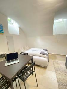 een slaapkamer met een bed en een laptop op een tafel bij Cozy Flat near City Center - Souterrain - Limited Free Parking in Innsbruck