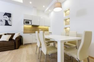 cocina y comedor con mesa blanca y sillas en Center Avenue Apartments, en Vilna
