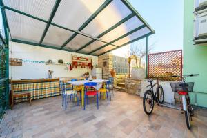 un patio con mesa, sillas y bicicleta en ANDREA house with apartments, en Umag