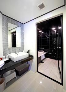 a bathroom with a tub and a sink and a shower at Hotel Sun Plaza Sakai Annex in Sakai