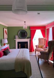 1 dormitorio con 1 cama, 1 silla y chimenea en The Inn at Loch Tummel, en Tummel Bridge