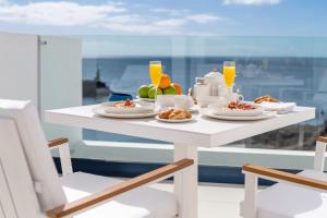 a table with plates of food and orange juice at Royal Marina Suites Boutique Hotel in Puerto Calero