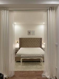 um quarto com uma cama com cortinas brancas em Helen Homestay Žižkov em Praga