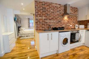 a kitchen with a brick wall and a washer and dryer at Cathedral View apartments in Lincoln +16 photos