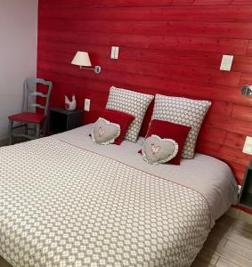 1 dormitorio con 1 cama grande y pared roja en Le Gîte les Châtaignes en Volvic