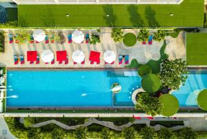 uma vista superior de uma piscina com cadeiras e mesas em Ramada by Wyndham Phuket Deevana Patong - SHA Extra Plus em Patong Beach