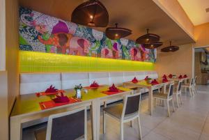 a restaurant with tables and chairs and a colorful wall at Ramada by Wyndham Phuket Deevana Patong - SHA Extra Plus in Patong Beach